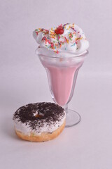 bebida y dona en un fondo rosa