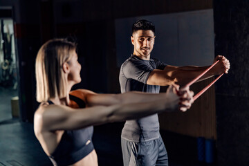 A happy fitness couple excising together with fitness band at the gym.