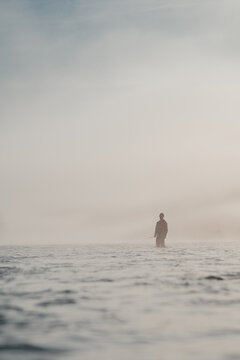 Telephoto Angle Of A Male Angler Spey Fishing For Wild Steelhead On Scenic River In The Fog