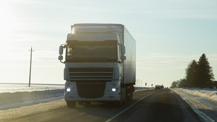 Heavy European white semi truck on winter road in Europe. White hauler front view. Transportation logistics.