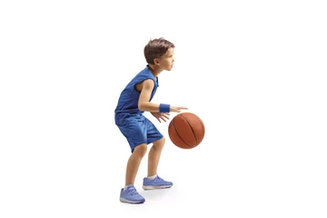 Poster Full length profile shot of a boy in a blue jersey playing basketball © Ljupco Smokovski