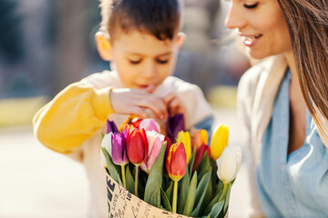 A little boy with his mother and flowers for mother's day.