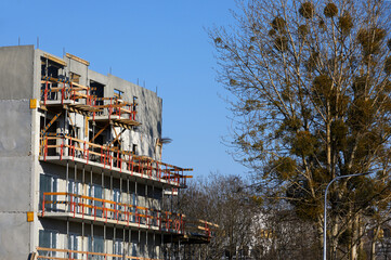 Fototapeta na wymiar Budowa domu. Fasada z tarasem i balkonem w trakcie budowy