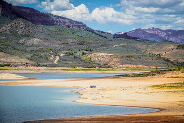 Almost dried up Blue Mesa Reservoir near Gunnison Colorado USA with pickup parked down near water and someone floating