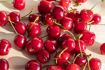 Close-up photo showing the texture of fresh red cherries on a wooden table; beautiful background photo