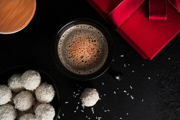 Coconut candies with nuts on dark background. Raffaello on black background.