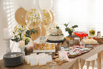Baby shower party. Different delicious treats on wooden table and decor indoors