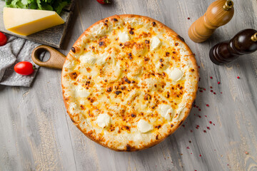 Cheese pizza on board on grey table top view