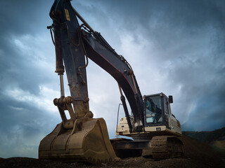 Close-up of xcavator scoop and jib during construction works. Heavy machinery at earthmoving,...