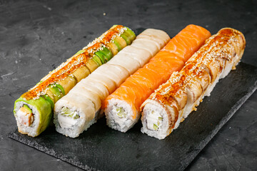 appetizing set of sushi roll on a black stone plate