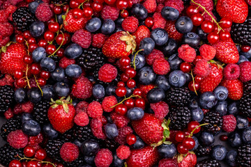 Various fresh summer berries backgrounds. Strawberry, blueberry, raspberry red currant and blackberry mix. Top view, flat lay.