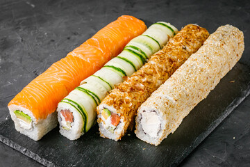 appetizing set of sushi roll on a black stone plate