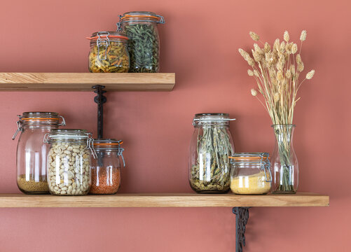 &Eacute;tag&egrave;res de cuisine en bois avec bocaux et mur couleur terracotta