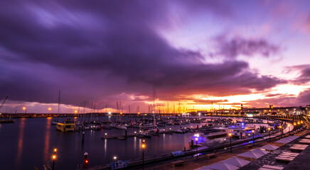 Sunset and clouds, marina with boats, vivid colors, Ponta Delgada, Azores.