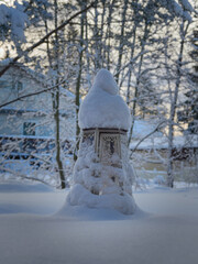 After a snowfall at a house in Europe: a lot of snow, household items under snow, Christmas lantern.