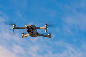An unmanned quadcopter with a digital camera in the blue sky.