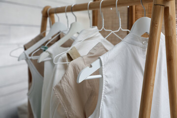 Rack with stylish women's clothes in dressing room, closeup