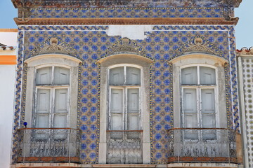 Fototapeta na wymiar Blue and yellow tile facade-old abandoned townhouse-closed balconies. Tavira-Portugal-110