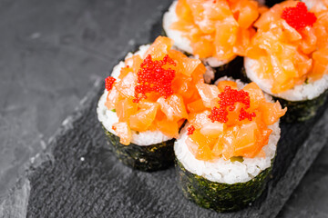 appetizing sushi roll maki with salmon on a black stone plate © Narsil