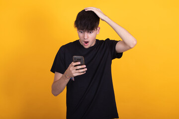 isolated young boy surprised looking at mobile phone