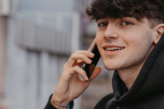 Teenager Talking On Mobile Phone In The Street