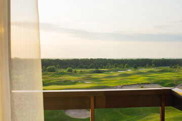 View from the balcony to the green beautiful golf course. Beautiful sunset. Travel Ukraine.