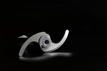 Rotary circular knives-blades of the nozzle of a hand-held immersion blender on a black background....