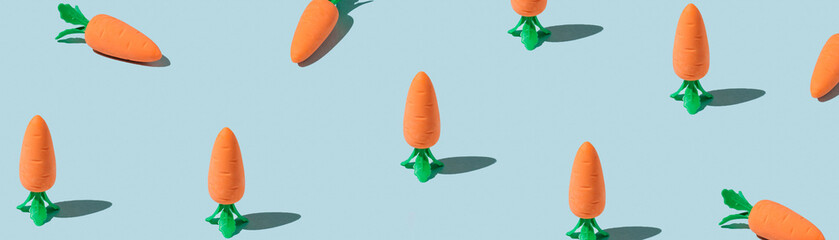 Banner made Easter pattern made with carrots on blue background. Creative minimal holiday concept. Flat lay, top view