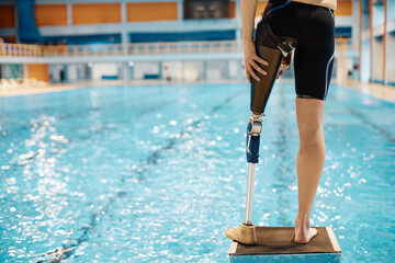 Rear view of swimmer with prosthetic leg at starting block.