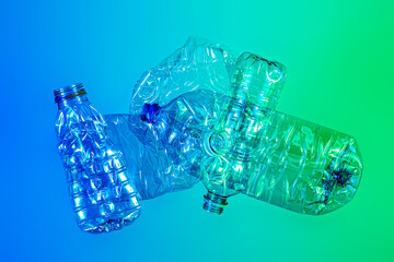 Recycling and ecology - crushed plastic bottles on blue and green background