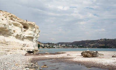 Young woman standing at the edge of a cliff enjoying the sea scenery. Pissouri coastline Limassol Cyprus