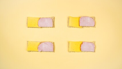 Four rectangular sandwiches with cheese and ham.
