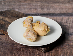 Steamed or boiled chicken thigh on dark wooden background, stock photo, selective focus