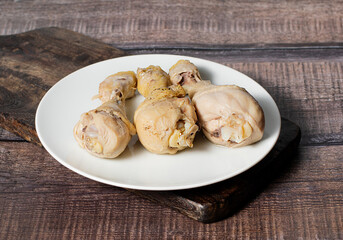 Steamed or boiled chicken thigh on dark wooden background, stock photo, selective focus