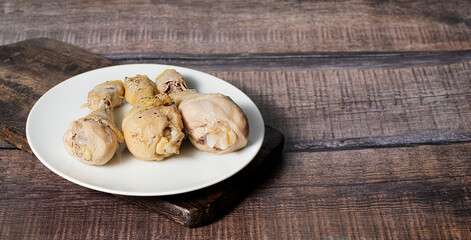 Steamed or boiled chicken thigh on dark wooden background, stock photo, selective focus
