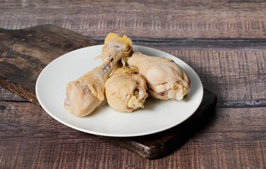 Steamed or boiled chicken thigh on dark wooden background, stock photo, selective focus