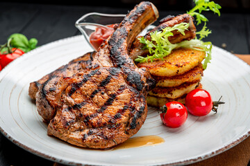 Pork steak with bone and potato pancakes