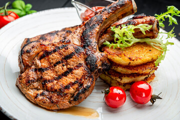 Pork steak with bone and potato pancakes