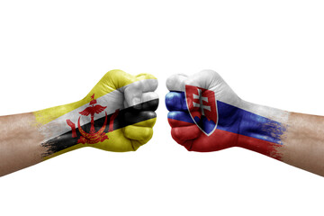 Two hands punch to each others on white background. Country flags painted fists, conflict crisis concept between brunei and slovakia