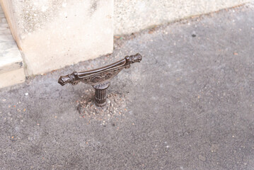 Decrottoir on the pavement in Rome. On the street, the pavement was changed to asphalt, but the old decrotoir was not dismantled.