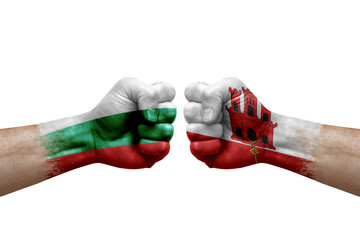 Two hands punch to each others on white background. Country flags painted fists, conflict crisis concept between bulgaria and gibraltar