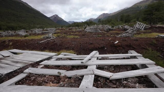 Environmental damage. View of an abandoned factory of natural peat bog exploitation. The red peat field of moss Sphagnum magellanicum, forest and Andes mountains in Ushuaia, Patagonia Argentina.