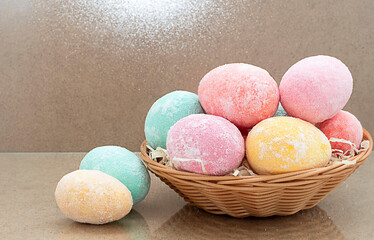 Easter eggs multi-colored in a basket on a wooden background, copy space. bokeh