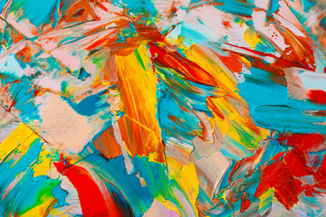 Closeup view of artist's palette with mixed bright paints as background