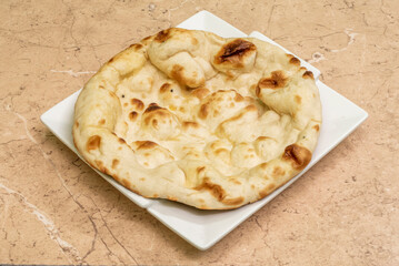 Naan is a flat bread, made from wheat flour and usually leavened. It is commonly consumed in various regions of Central Asia and South Asia.