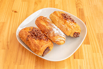 Sweet Neapolitans filled with pastry cream and chocolate and sprinkled with icing sugar and chocolate chips