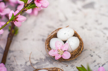 Spring blossom, Easter concept, miniature bunny, flowering tree close-up and copy space. Pink natural texture of natural flowering tree. Easter egg and branches of blossoming on an table..