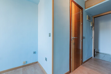 Study with light blue painted walls and hardwood floors and a cherry wood door