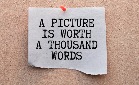 A picture is worth a thousand words Message. Recycled paper note pinned on cork board
