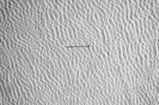 Aerial view of snow covered frozen lake with tiny figure and shadow